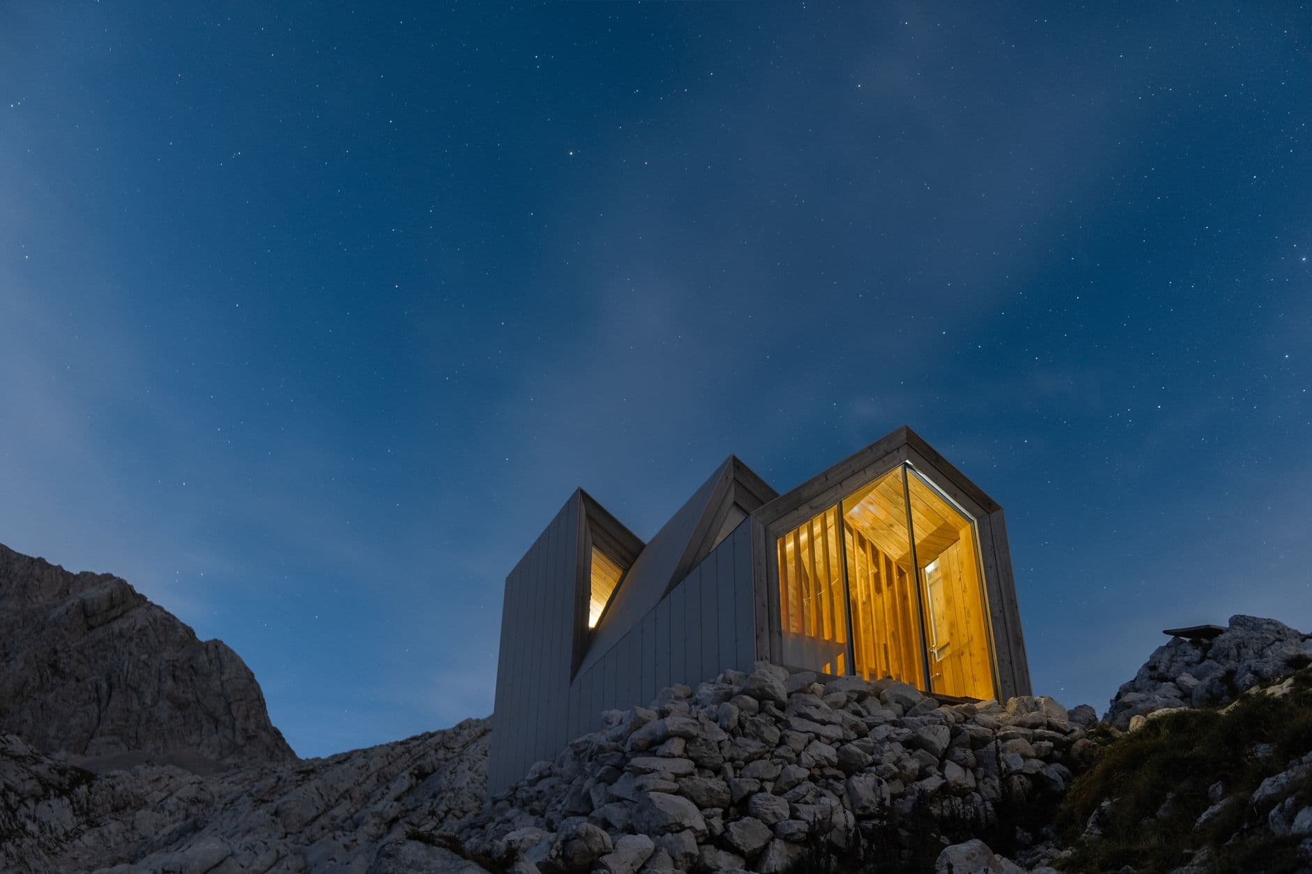 Dos módulos de una casa iluminados de noche.